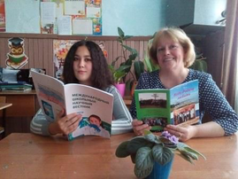 Илларионова Александра, ученица 10 класса, читает в журнале свою исследовательскую работу.
