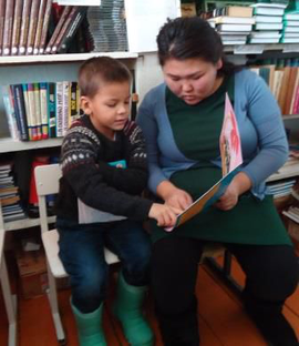 Учитель начальных классов Ринчинова С.Н. и ученик 2 класса Кузыченко Слава в школьной библиотеке