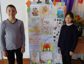 Павловец Данил и Че Анна возле выставки рисунков "Краски осени"